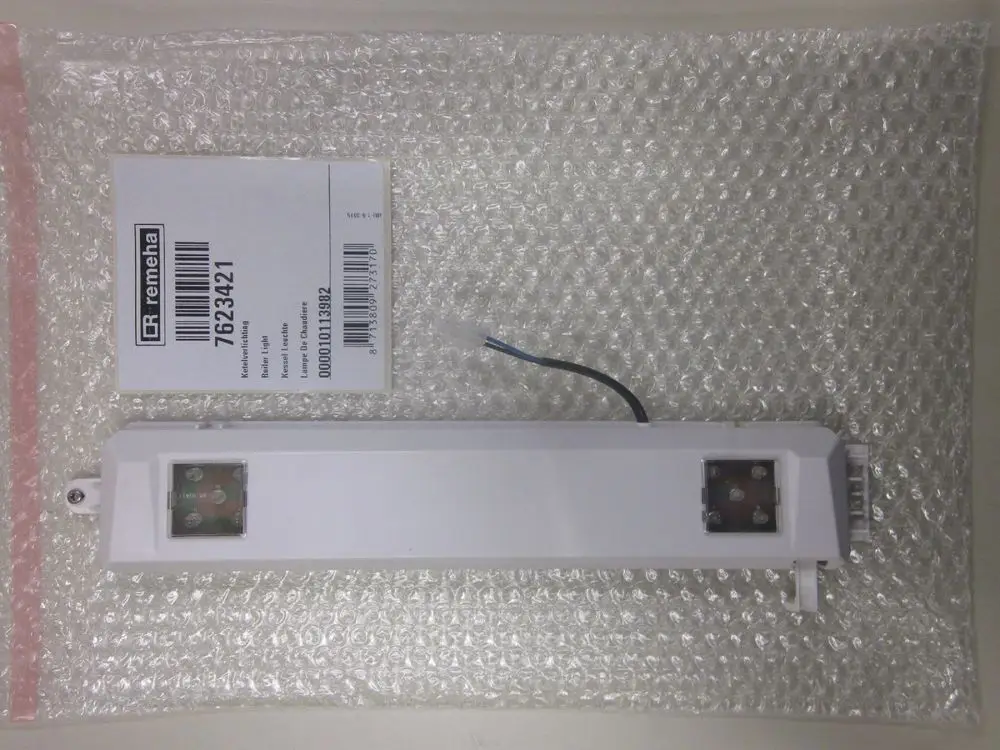 Lichteinheit von Remeha in Schutzverpackung, montiert mit Anschlüssen und Kabeln. Etikett mit Artikelnummer sichtbar.